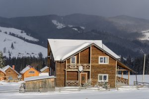 Fantastic winter landscape with wooden house in snowy mountains.